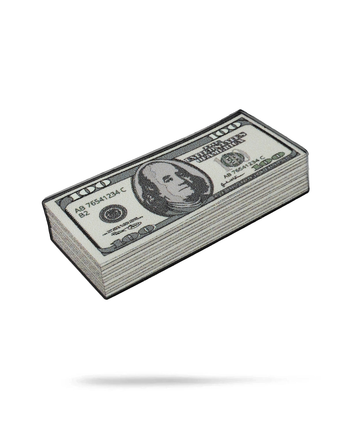 A Cash Stack Ball Marker by Pins and Aces is displayed on a white background next to a stack of U.S. hundred dollar bills, both casting subtle shadows below.