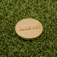 An orange "Slice" Premium Ball Marker from Logie Joe's Golf rests on green artificial grass.