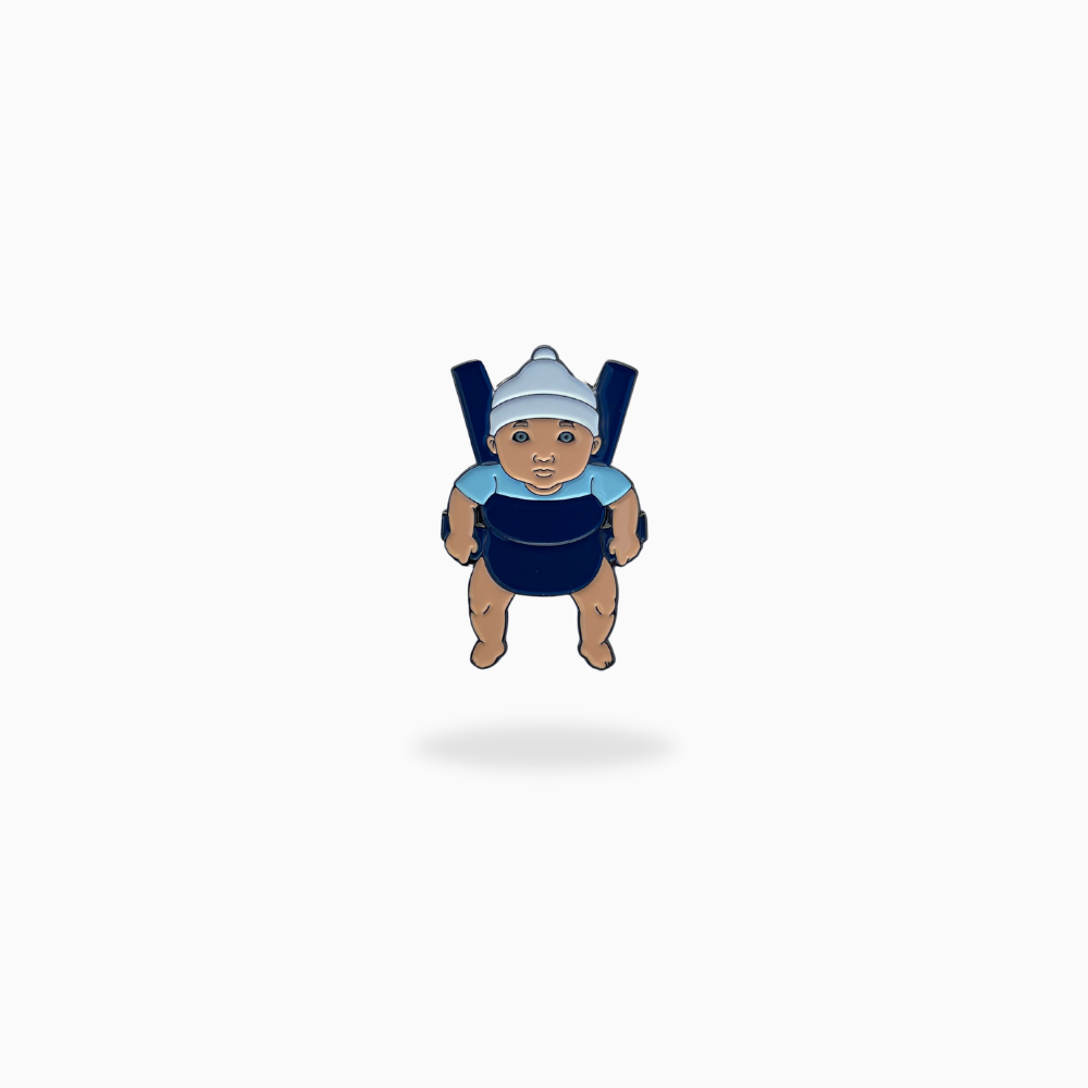 A cartoon baby in a blue outfit and white hat sits in a dark blue carrier with an "Are You Hungover?" golf ball marker by Pin Creatures, set on a plain white background.