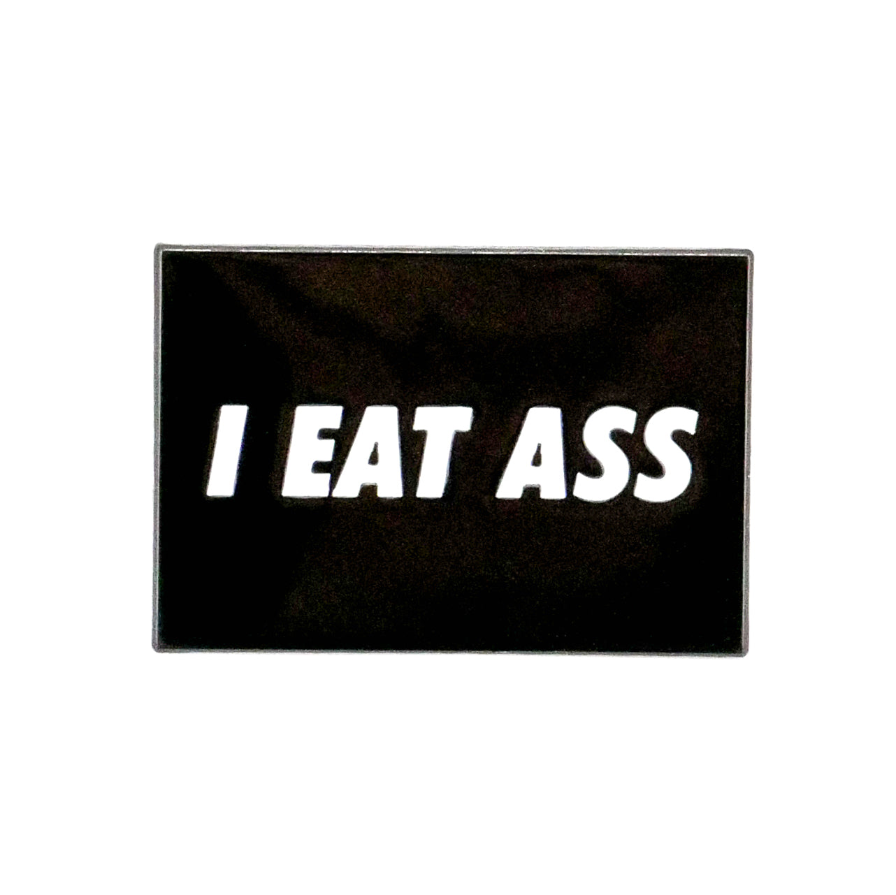 The Jogie Loes "I Eat A** Ball Marker" is a black, rectangular golf accessory with bold white text—perfect for sparking conversation on the green.