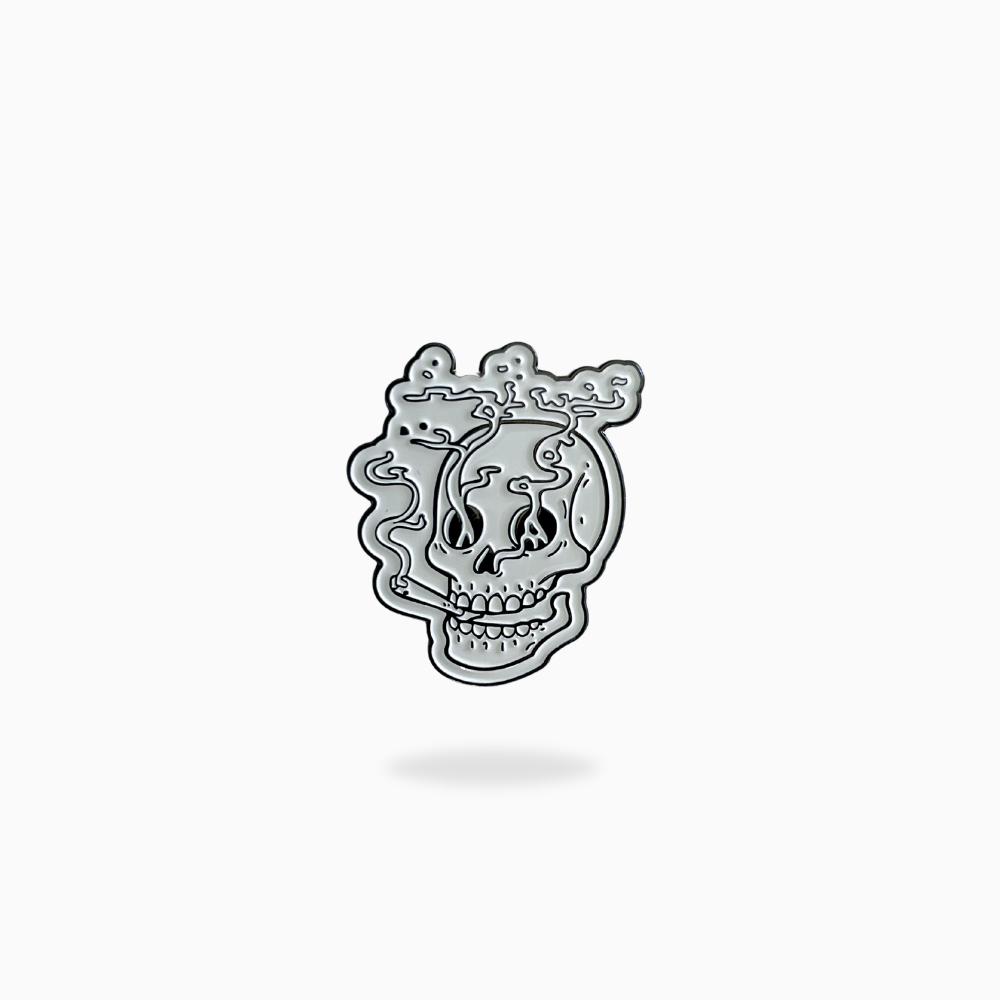 The Pin Creatures Smoking Skull golf ball marker features a silver skull with abstract swirling lines, shown on a plain white background.