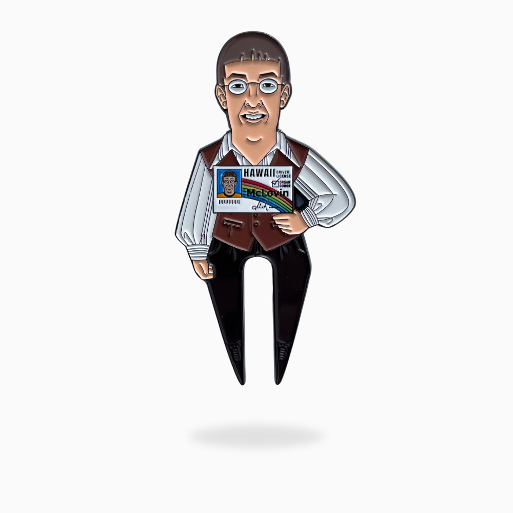 The Pin Creatures McLovin Divot Tool is a metal golf accessory shaped like a person in glasses and a vest, holding a Hawaii ID card with "McLovin," shown on a plain white background with a slight shadow below.