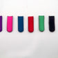 Six BYRD GOLF DIVOT CLYP fabric clips by The Byrd, LLC—purple, pink, blue, red, green, and black—are lined up on a white background. Low stock! Organize your golf gear and grab yours now before they're gone!.