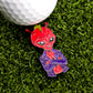 The Slice Vicious Ball Marker by Ballmarkers.com features a red alien in a purple jacket and yellow crown, arms crossed on green turf beside a white golf ball—a bold Punk Rock accessory for Alien golf headcover fans.