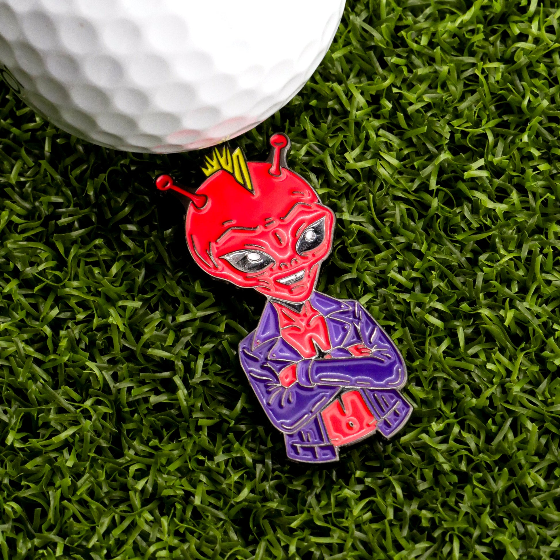 The Slice Vicious Ball Marker by Ballmarkers.com features a red alien in a purple jacket and yellow crown, arms crossed on green turf beside a white golf ball—a bold Punk Rock accessory for Alien golf headcover fans.