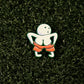 The Moon Man Ball Marker by Shank it Golf is a premium metal pin featuring a round-headed figure pulling down red shorts, shown on a dark green turf-like background—ideal for collectors or as a unique magnetic golf accessory.