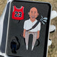 A gloved hand holds "The GOAT 23" pin set by Pin Creatures: a red #23 basketball jersey, a smiling bald man with an earring and golf bag, and a black ball marker, displayed on grass.