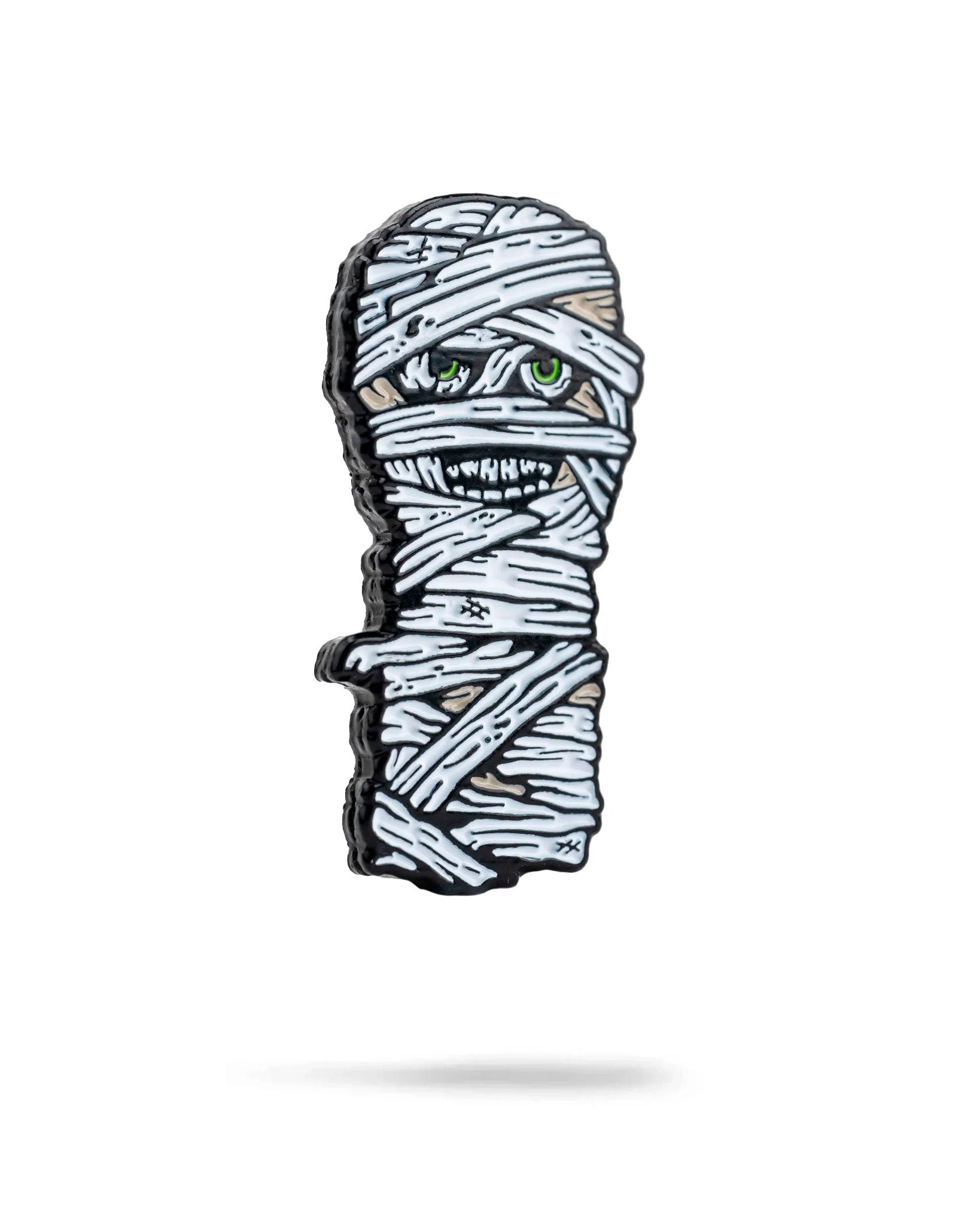 The Pins and Aces Mummy Ball Marker features a cartoon-style mummy wrapped in white bandages with green eyes and sharp teeth, finished in enamel with a magnetic back—perfect for standing out on the golf course.