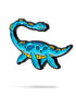 The Nessie Ball Marker by Pins and Aces is a colorful enamel golf ball marker shaped like a blue cartoon dinosaur with yellow accents, featuring a long neck and tail, shown on a white background.