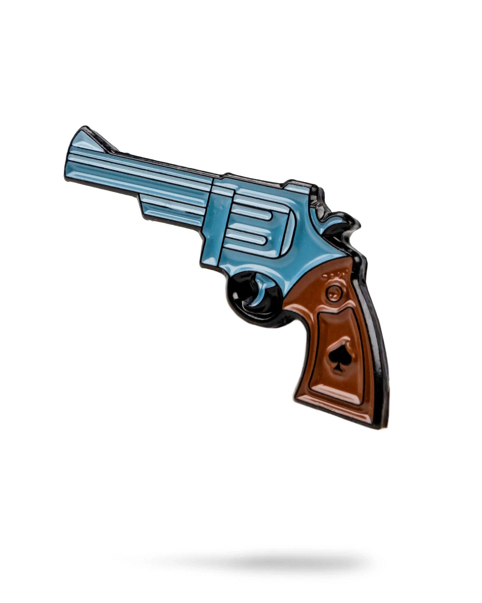 The Pins and Aces Revolver Ball Marker is a stylized stainless steel enamel pin shaped like a blue and brown revolver with a spade on the handle, shown on a white background with a subtle shadow.
