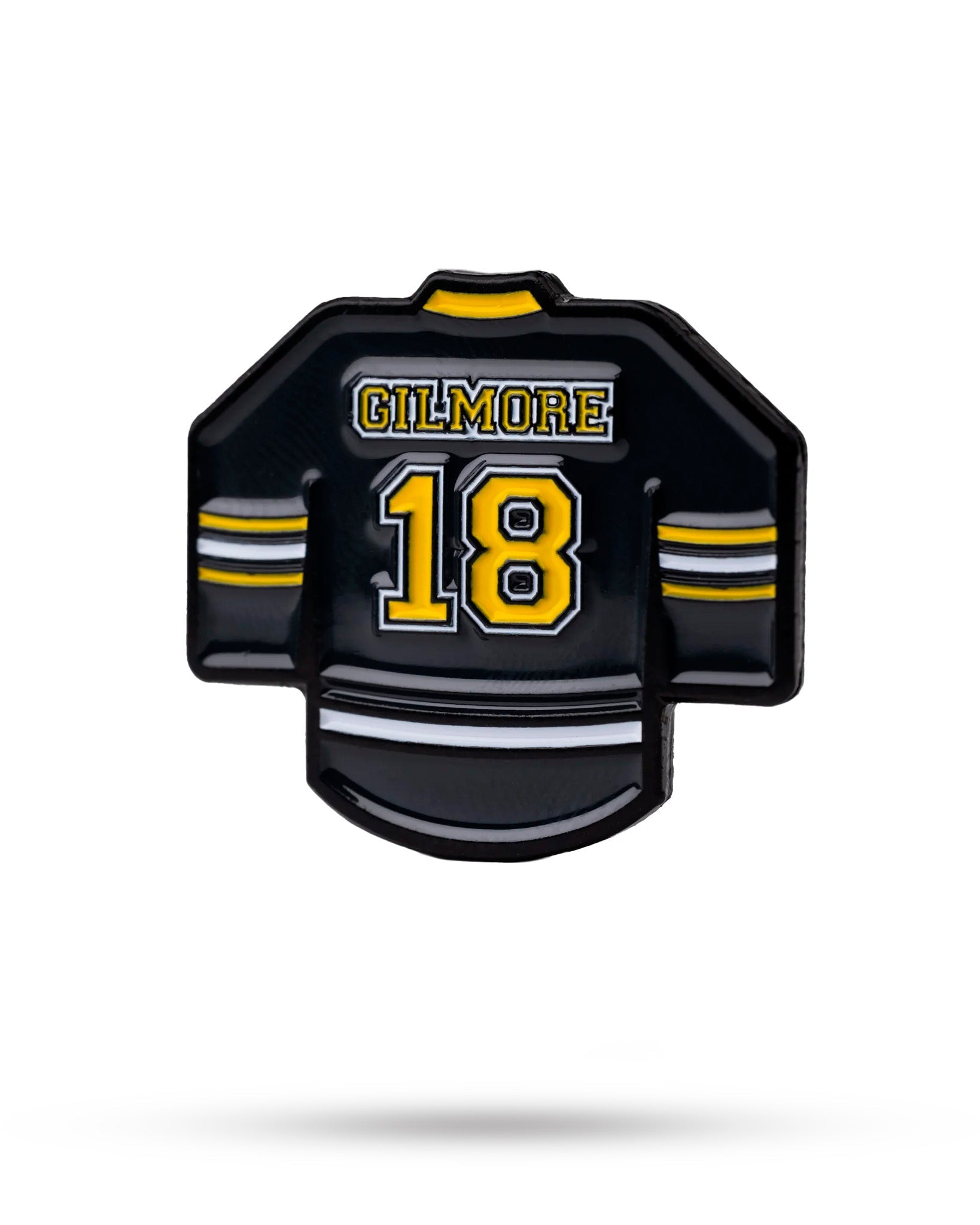 The Gilmore Jersey Ball Marker by Pins and Aces is a black enamel golf marker shaped like a hockey jersey, featuring yellow and white stripes, the name Gilmore, and bold yellow 18—perfect for sports fans.