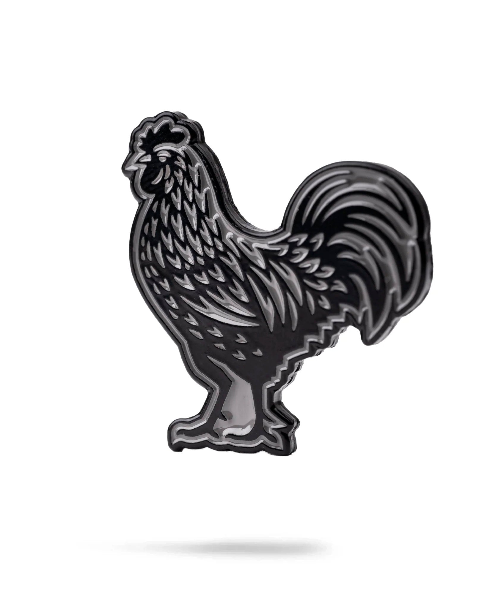 The Pins and Aces Black Cock Ball Marker is a black and silver enamel golf marker shaped like a rooster, displayed on a white background with a subtle shadow underneath.