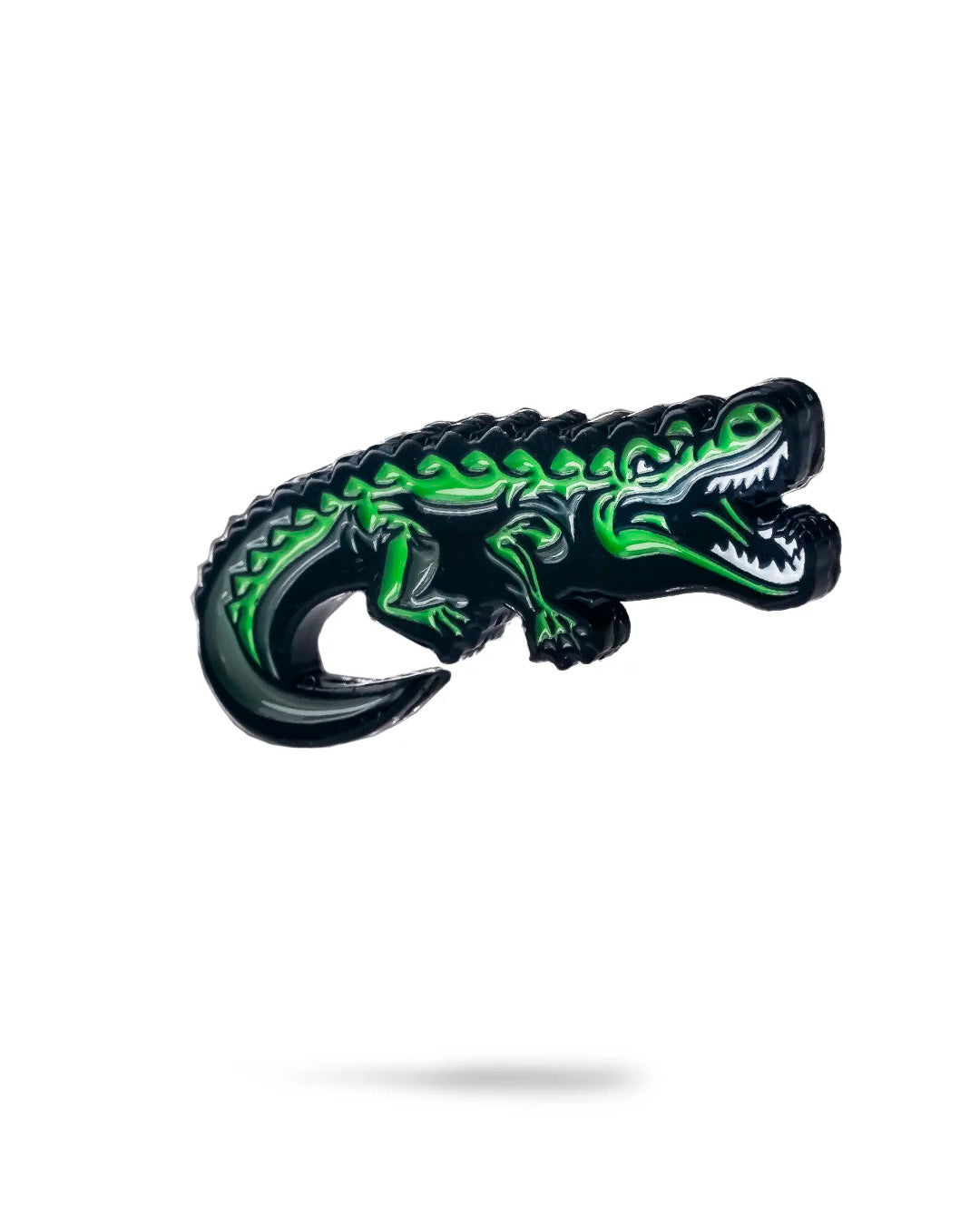 The Pins and Aces Crocodile Ball Marker features a green enamel crocodile with black and white details, its mouth open. Shown on a white background with a slight shadow, it's ideal for marking your golf ball on the course.