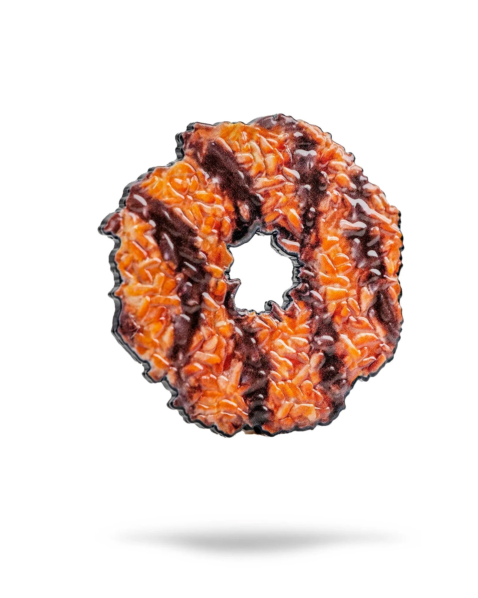 A close-up of the Pins and Aces Coconut Fudge Cookie Ball Marker, inspired by Samoa cookies with a ring shape and enamel finish, is displayed on a white background with a faint shadow below.