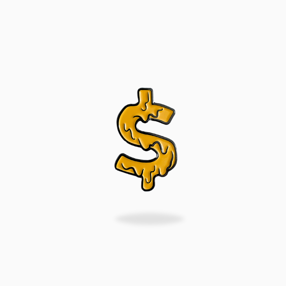 The Pin Creatures Money Sign Ball Marker, featuring a golden, hand-crafted design with a melting liquid texture, sits centered on a plain white background and casts a subtle shadow below.