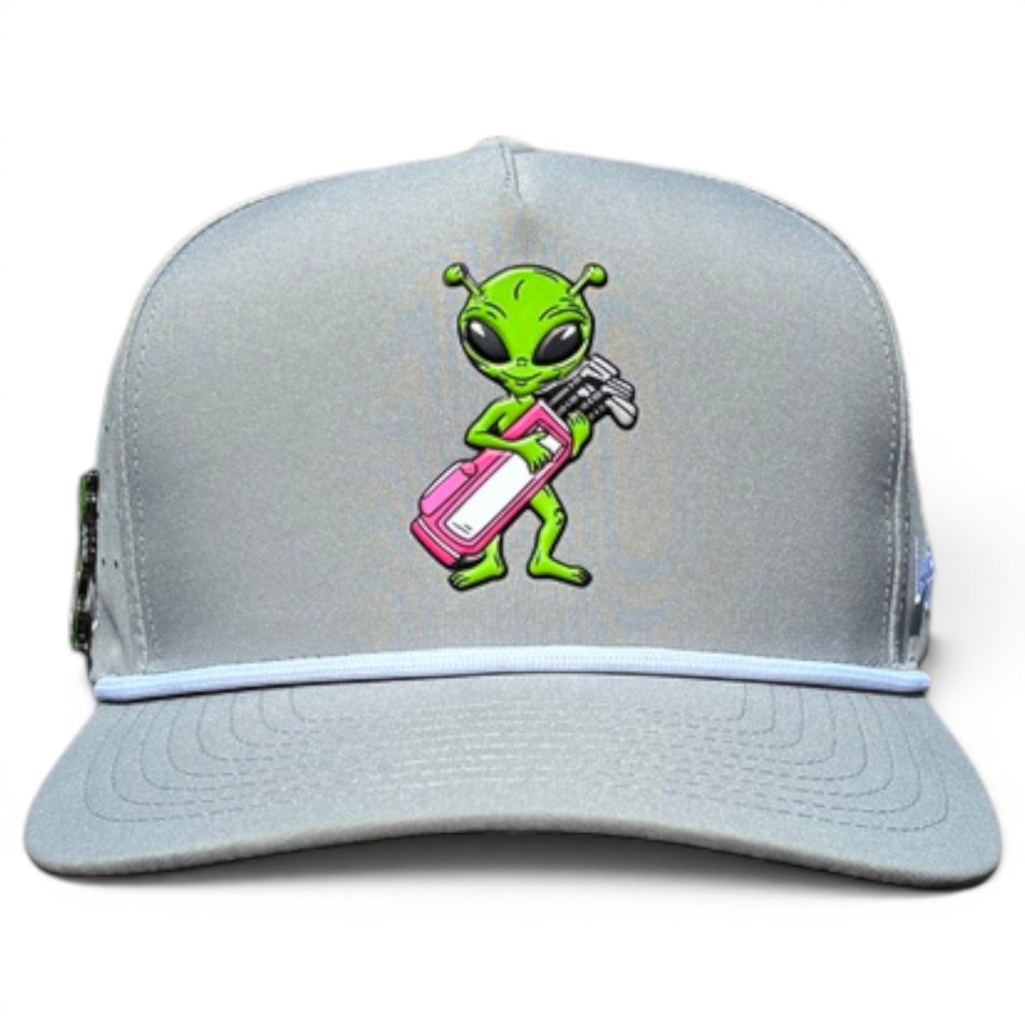 The Logie Joe's Golf Alien Caddy Golf Hat is a light gray snapback cap with a cartoon green alien holding a pink and white golf bag, curved bill, white accent line, and built-in magnetic ball marker holder plus marker included.