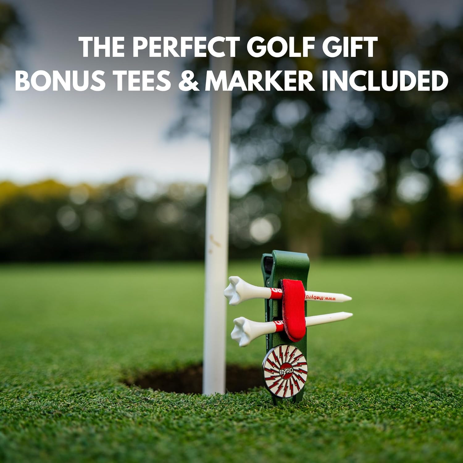 THE BYRD GOLF DIVOT CLYP by The Byrd, LLC clips to the green’s edge, organizing your golf gear. Includes bonus tees & marker. The perfect golf gift! HOT PRODUCT, LOW STOCK! Blurred trees in background.