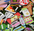 A close-up of vibrant enamel pins, including a golf bag and pizza slice, scattered on grass highlights the Custom Mystery Ball Marker Pack—unique golf ball markers that make standout premium accessories.