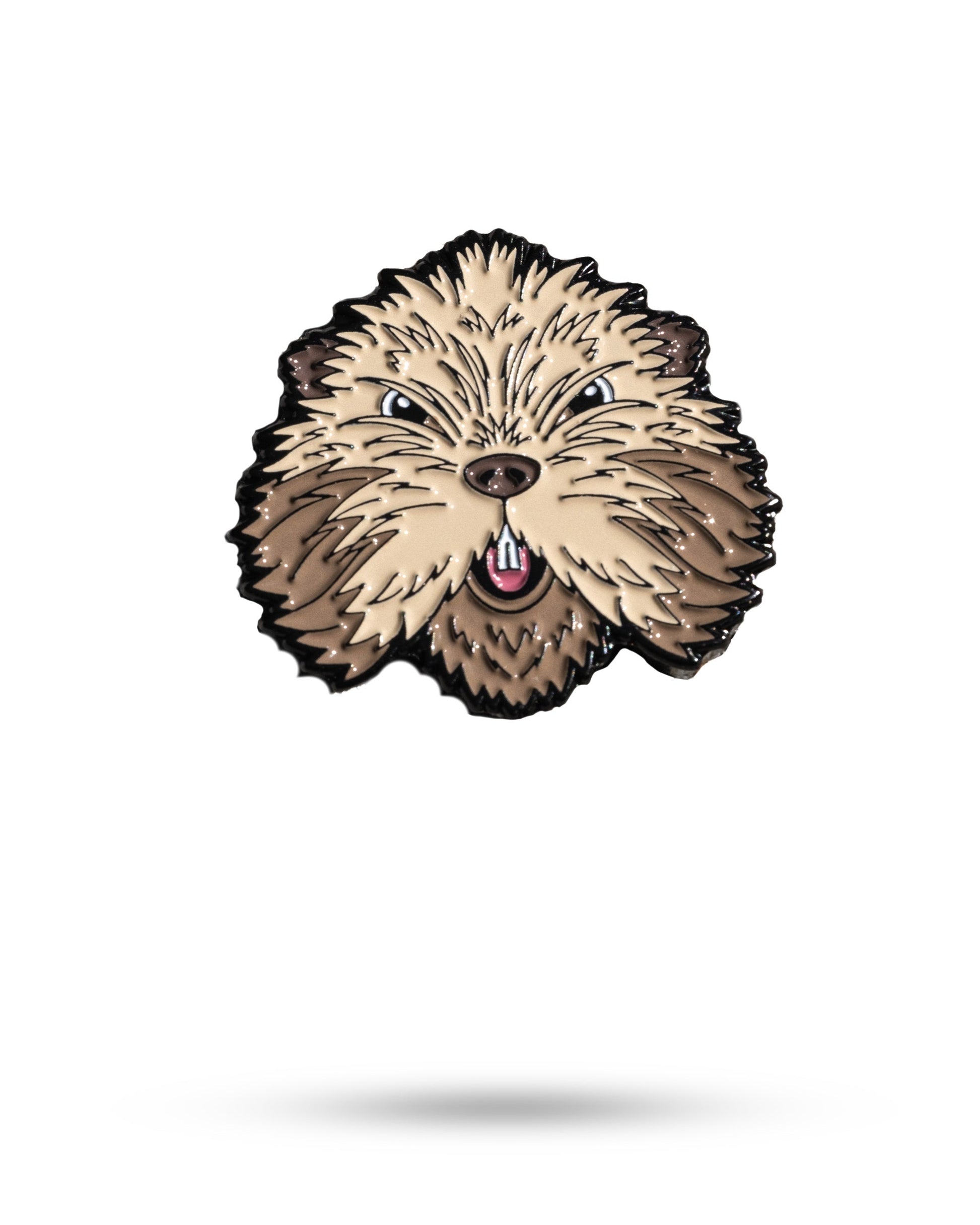 The Pins and Aces Gopher 2.0 Ball Marker is a metal enamel pin shaped like a fluffy dog's face, with beige and brown fur, pointed ears, and an open mouth with a pink tongue, crafted from cast stainless steel.