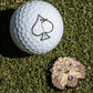 The Pins and Aces Gopher 2.0 Ball Marker features a golf ball with a spade symbol alongside a cute, fluffy brown dog—ideal for fun-loving golfers seeking playful style on the course.