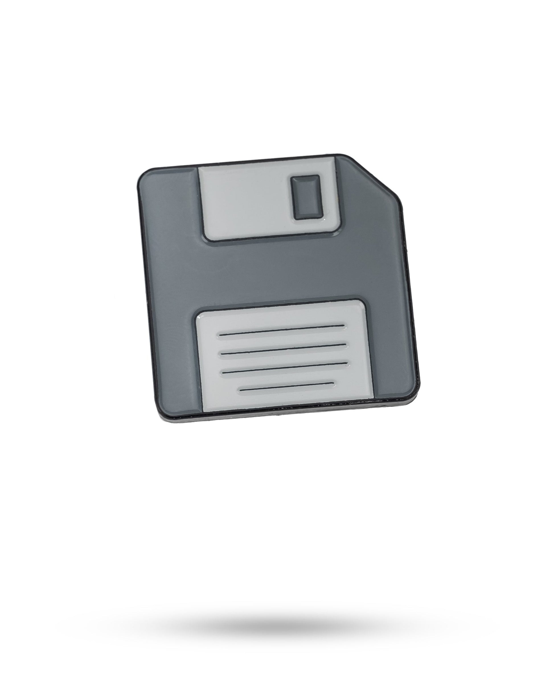 A grey and white Pins and Aces Floppy Disc Ball Marker icon appears on a white background, with a faint shadow beneath it.