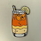 Illustration of Logie Joe's Golf "Half and Half Ball Marker"—a two-toned lemonade iced tea in a glass with ice cubes, a lemon slice, and a striped straw, set against a plain light background—perfect inspiration for your next golf accessory or ball marker design.