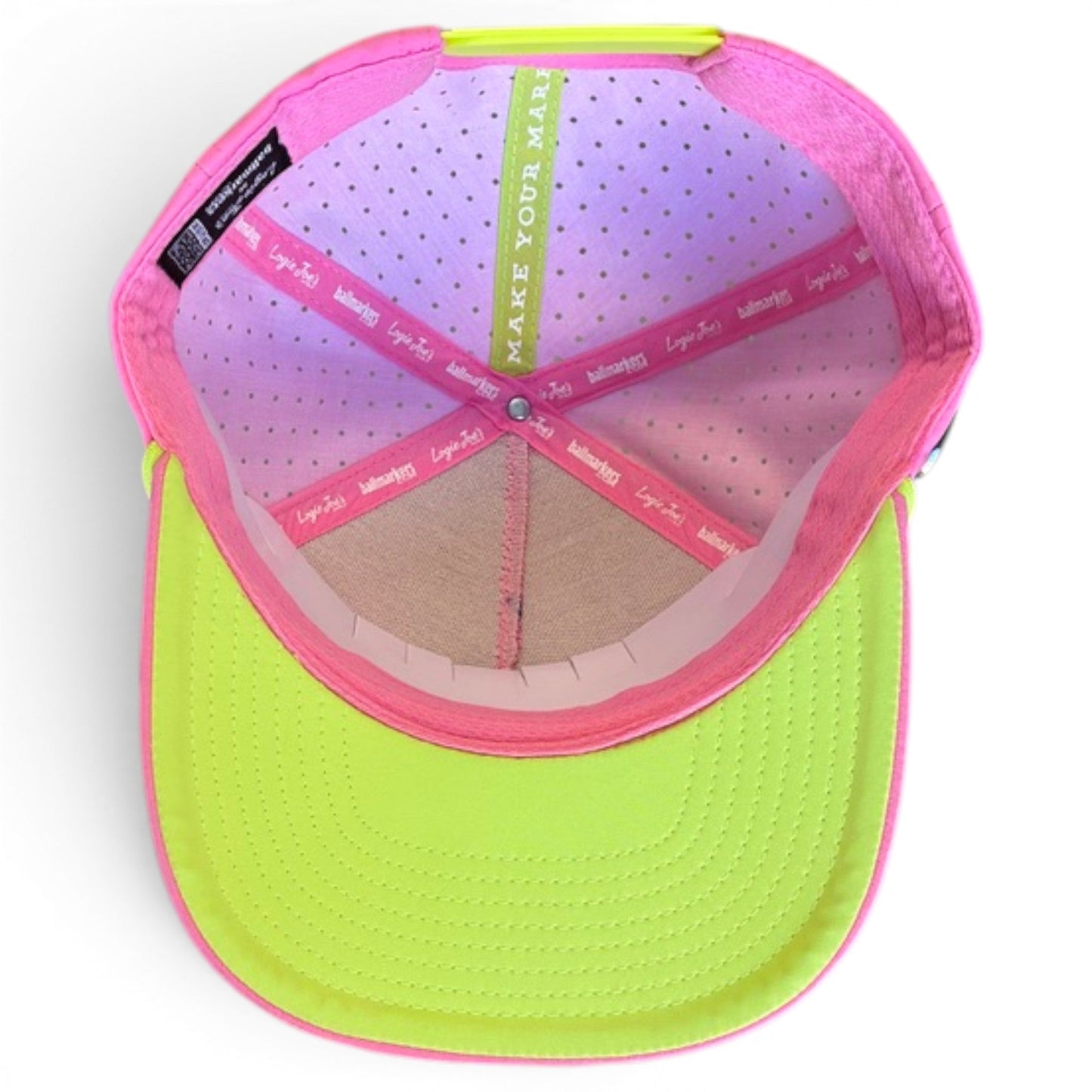 The underside of Logie Joe’s Golf Coconut Cocktail Snapback Cap shows pink and green interior bands—green reads “MAKE YOUR MARK,” pink bands repeat “Junk.” Adjustable fit, magnetic ball marker holder, and marker included. Neon yellow and pink design.