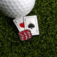 A close-up of Ballmarkers.com's Big Pair of Aces Ball Marker beside a golf ball, ace of hearts, ace of spades, and red poker chips on green grass.
