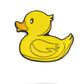 The Rubber Ducky Ball Marker by Pins and Aces features a cartoon-style yellow duck with an orange beak, outlined in black—perfect as a fun enamel golf ball marker on the course.