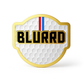 THE BLURRD PREMIUM BALL MARKER by BLURRD features a gold-bordered badge with a golf ball texture, bold black "BLURRD" text, and a vertical red, white, and blue stripe—perfect as a stylish golf accessory.