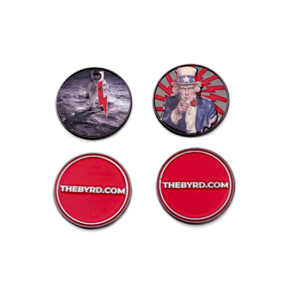 The Byrd, LLC’s BYRD BALL MARKERS - Merica includes four magnetic round pins—astronaut and Uncle Sam designs plus two red THEBYRD.COM markers—ideal as golf accessories or unique ball markers.