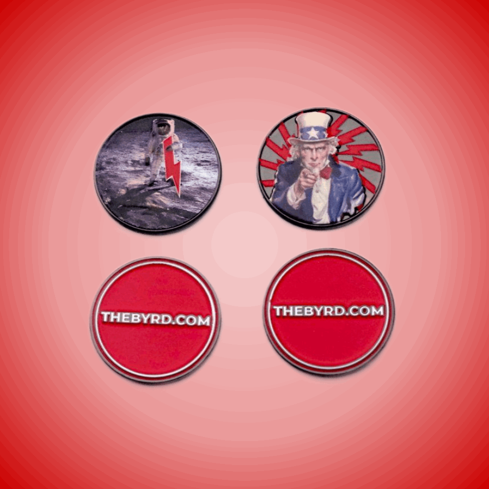 Four round BYRD BALL MARKERS - Merica by The Byrd, LLC are shown on a red gradient: an astronaut with red lightning, vintage Uncle Sam, and two with "THEBYRD.COM"—perfect as unique golf ball markers or magnetic golf accessories.