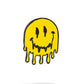 The Pins and Aces Melting Face Ball Marker features a melting yellow smiley with black eyes and mouth on white, complete with drips—perfect for adding unique style to your game thanks to its stainless steel magnetic surface.