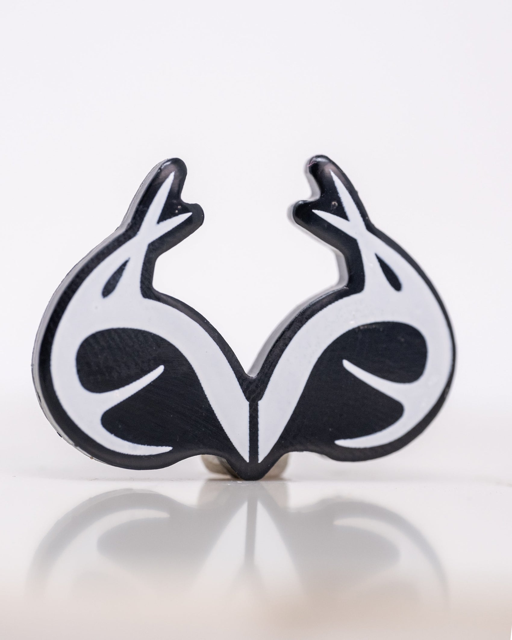 A Real Tree Antlers Ball Marker by Pins and Aces, featuring stylized antler shapes forming a heart-like design, shown on a white background with a subtle reflection below.