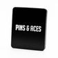 A black rectangular holder with "PINS & ACES" in bold white on the front, made for the Pins and Aces Be A Good Person Ball Marker, stands out against a plain white background.
