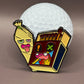 The Best Buds Ball Marker by Crown Golf Designs is a vibrant metal enamel pin set, featuring a quirky banana and matchbox duo with expressive faces, displayed in front of a golf ball on a neutral background.