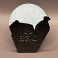 A white golf ball rests in a magnetic black metal Arkansas-shaped holder engraved with "Best Buds Ball Marker" by Crown Golf Designs, set against a plain brown background.