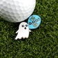 A Logie Joe's Golf "Boo Bees" ball sits on grass next to ghost-shaped markers and a blue “Boo!” pin with bees—ideal for fans of fun golf accessories.