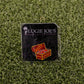 The "Bout That Booty" pin from Logie Joe's Golf features a colorful treasure chest and doubles as a premium ball marker, packaged on branded carding with an artificial grass background.