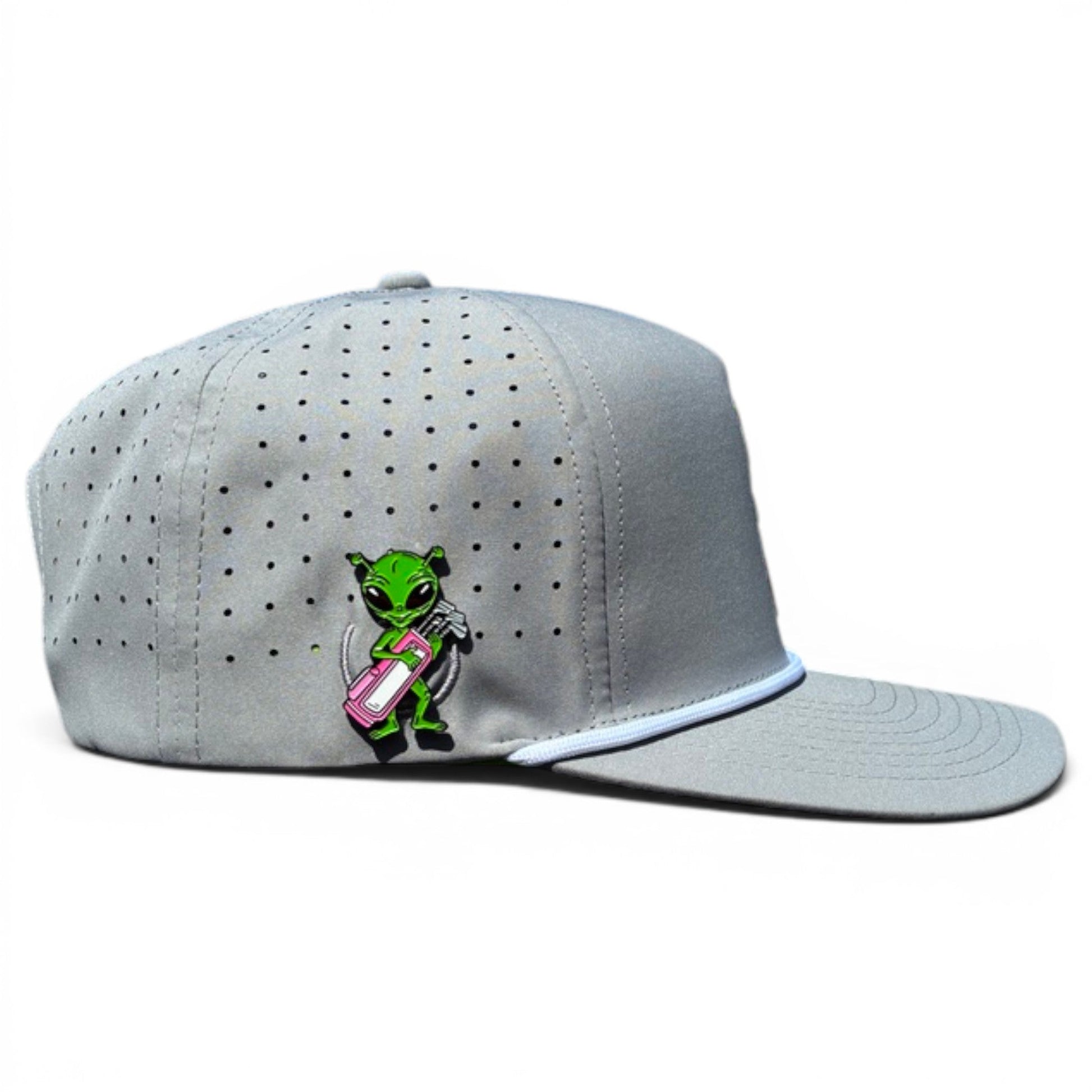 The Logie Joe's Golf Alien Caddy Golf Hat is a light gray adjustable snapback cap with white trim, built-in magnetic ball marker holder plus marker, and features a green alien pin holding a pink surfboard on the front.