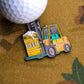 Next to a golf ball is the Ballmarkers.com Beer Delivery Ball Marker, a vibrant enamel pin of a yellow forklift lifting a BEER-labeled keg—ideal for golfers who love beer and camaraderie on the course.