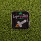 Add humor to your game with the Cocketship pin from Logie Joe’s Golf—shaped like a rocket and packaged with a flamingo and palm tree motif atop artificial grass.
