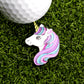 The Cute Unicorn Ball Marker from Ballmarkers.com, featuring a pastel purple and blue mane, sits on green turf beneath a white golf ball—a whimsical addition to any putting marker collection.