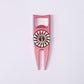 The Byrd, LLC BYRD DIVOT TOOL - 4 in 1 is a pink metal golf divot tool and ball marker holder with a white circular emblem featuring red lightning bolts and "REVOLT" in the center, shown on a plain white background.