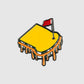 A stylized illustration of Guerrilla Golf’s Pimento Ball Marker depicts a grilled cheese sandwich with melted cheese, shaped like a golf green and topped with a small red flag pin. Vibrant accents are added using an edible marker to highlight the details while keeping the design food safe.