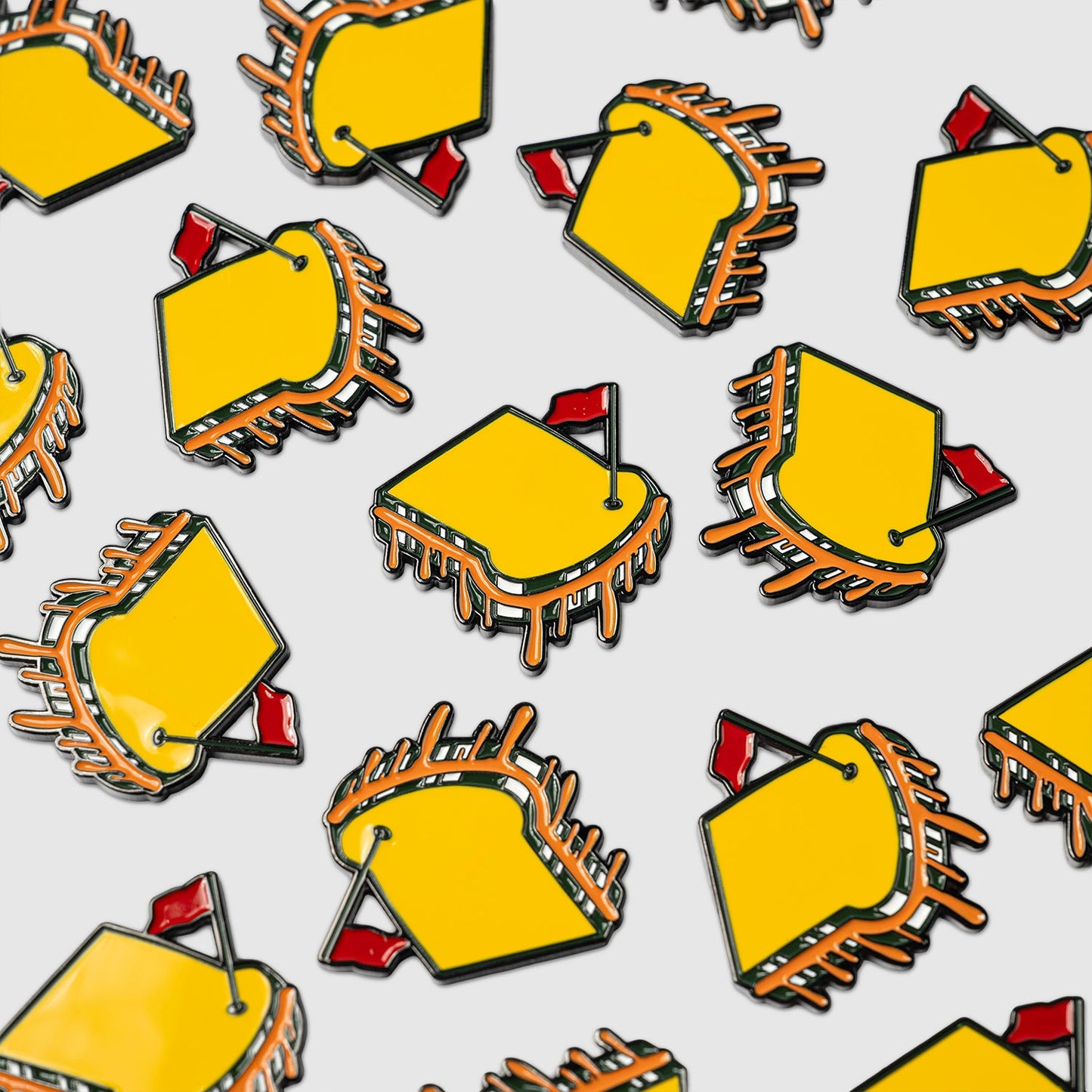 Several Guerrilla Golf Pimento Ball Markers—yellow rectangles with orange edges and a small red flag—are arranged on a white background, resembling artfully decorated treats for a playful, food-inspired effect.