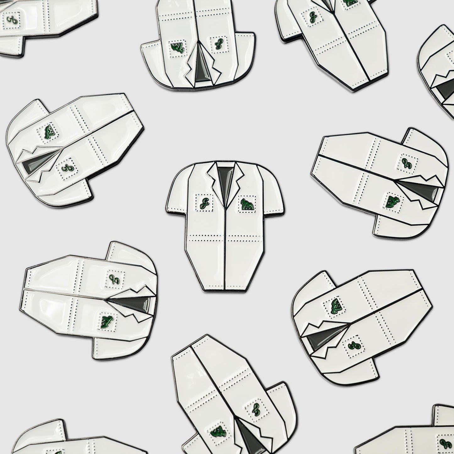 Pattern of white Guerrilla Golf Caddy Bib Ball Markers shaped like lab coats, with green patches and pocket details—each designed as a novelty marker—arranged evenly on a light gray background.