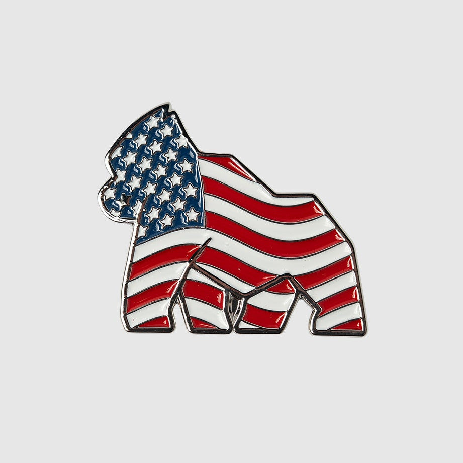 Introducing the American Flag Gorilla Ball Marker by Guerrilla Golf—a striking gorilla silhouette pin adorned with stars on the face and upper body and bold red and white stripes along the rest of its form. This eye-catching marker captures true American spirit, adding a proud, patriotic flair to your collection—much like a confident golf putting stroke against a plain light background.