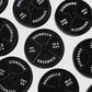 Several black 45lb Plate Ball Markers from Guerrilla Golf, each labeled GUERRILLA STANDARD 45 LBS 20.4 KGS, are arranged on a white background and viewed from above, resembling the classic 45 plates found in gyms.