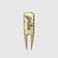 The Guerrilla Golf GRLA Raw Divot Tool, crafted from brass and engraved with "Spla," showcases textured edges and the official GRLA logo. Presented against a plain light gray background, this accessory embodies elegance for every golf enthusiast.